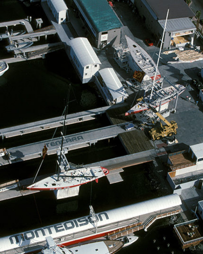 Yachts being loaded onto a ship at a dock
