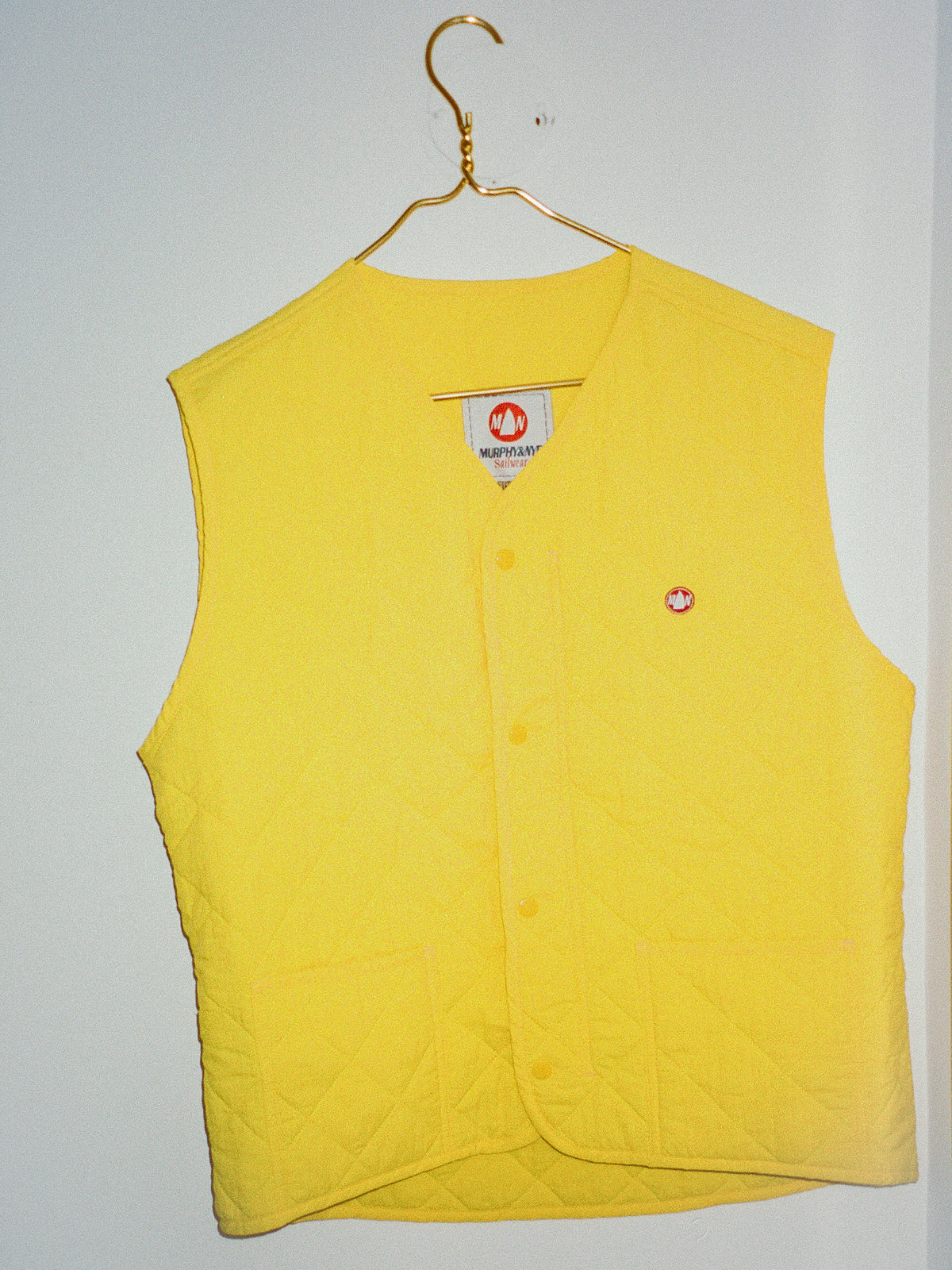 Yellow vest with a brand label on a white background