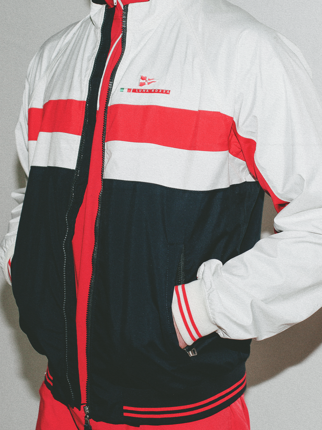 Multicolored jacket with red, black, and white design on a plain background