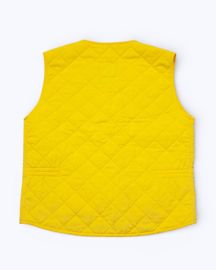 Yellow quilted vest on a white background