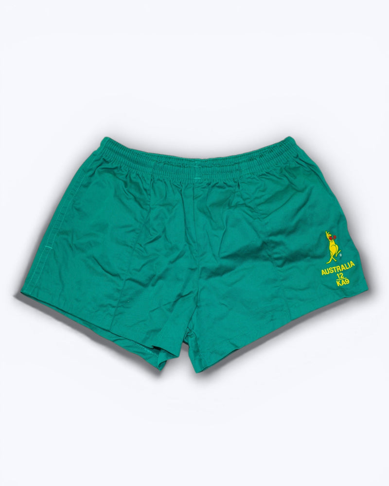 Green shorts with a yellow logo on a white background