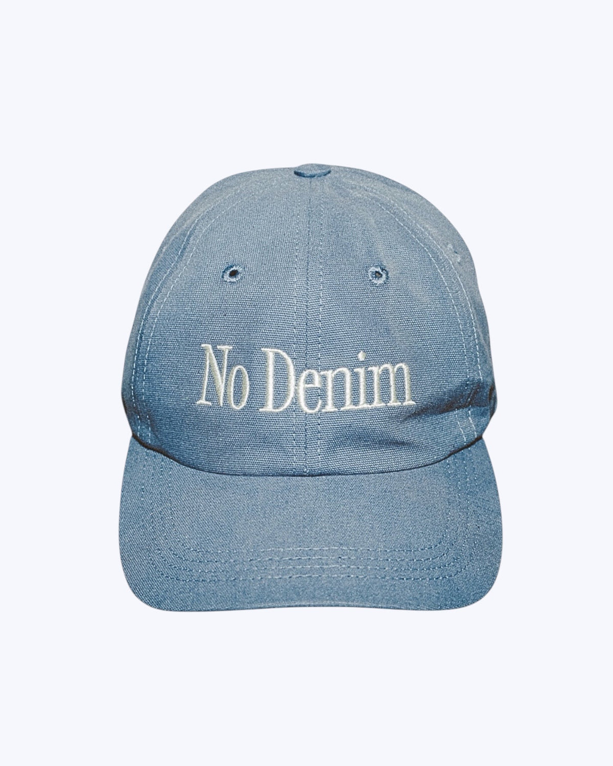 Blue denim cap with 'No Denim' text on a white background
