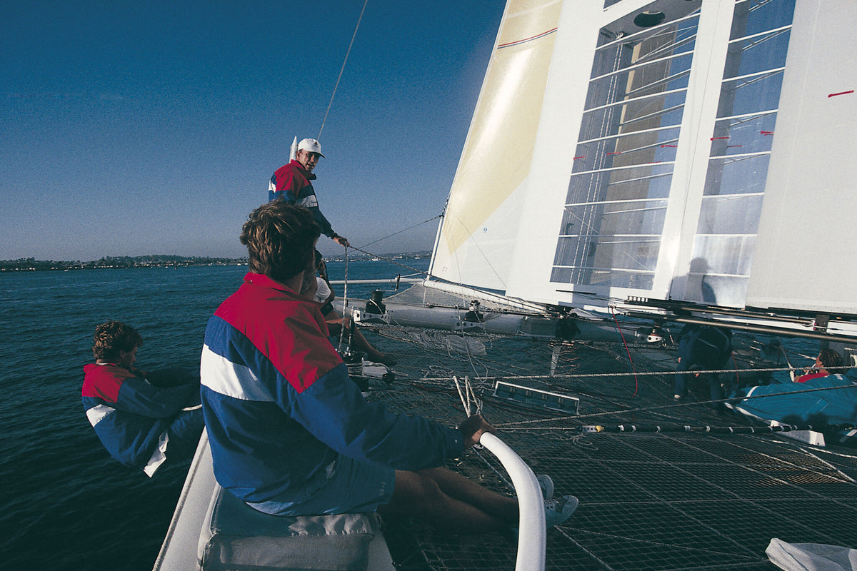 People on a sailboat with a clear blue sky and water background