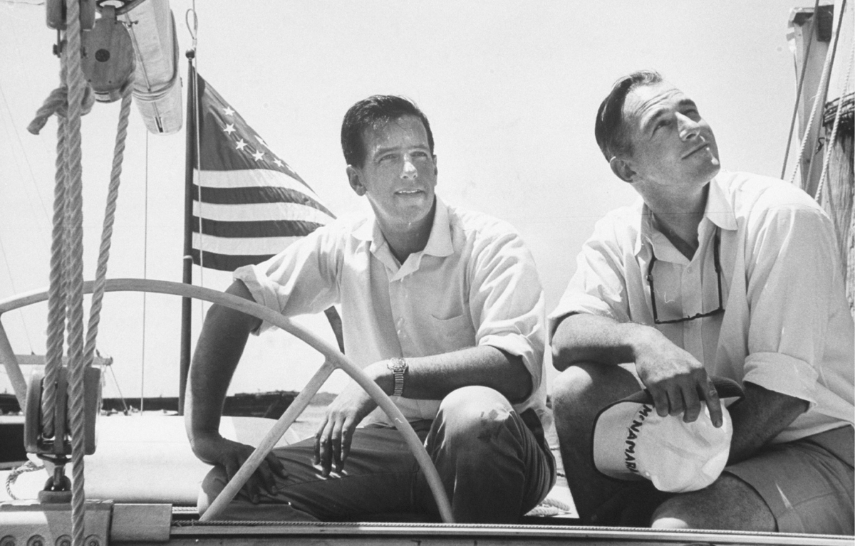 Two men on a boat with an American flag in the background