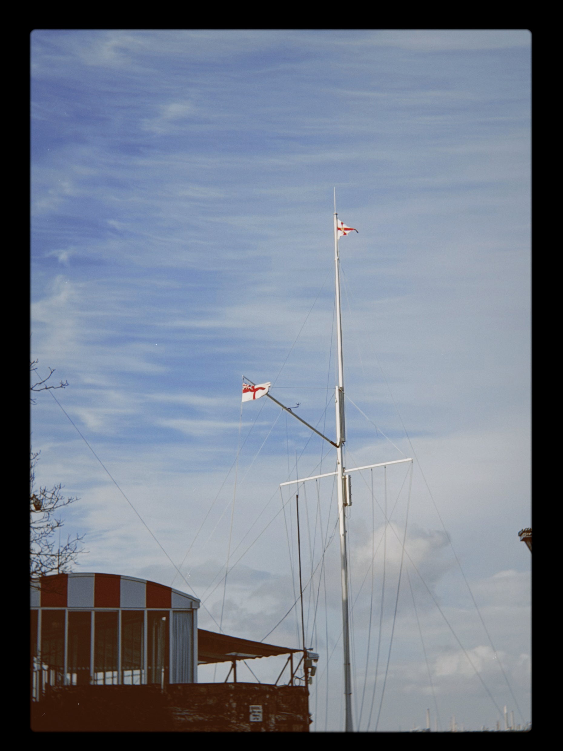 Flagpole with flags against a blue sky