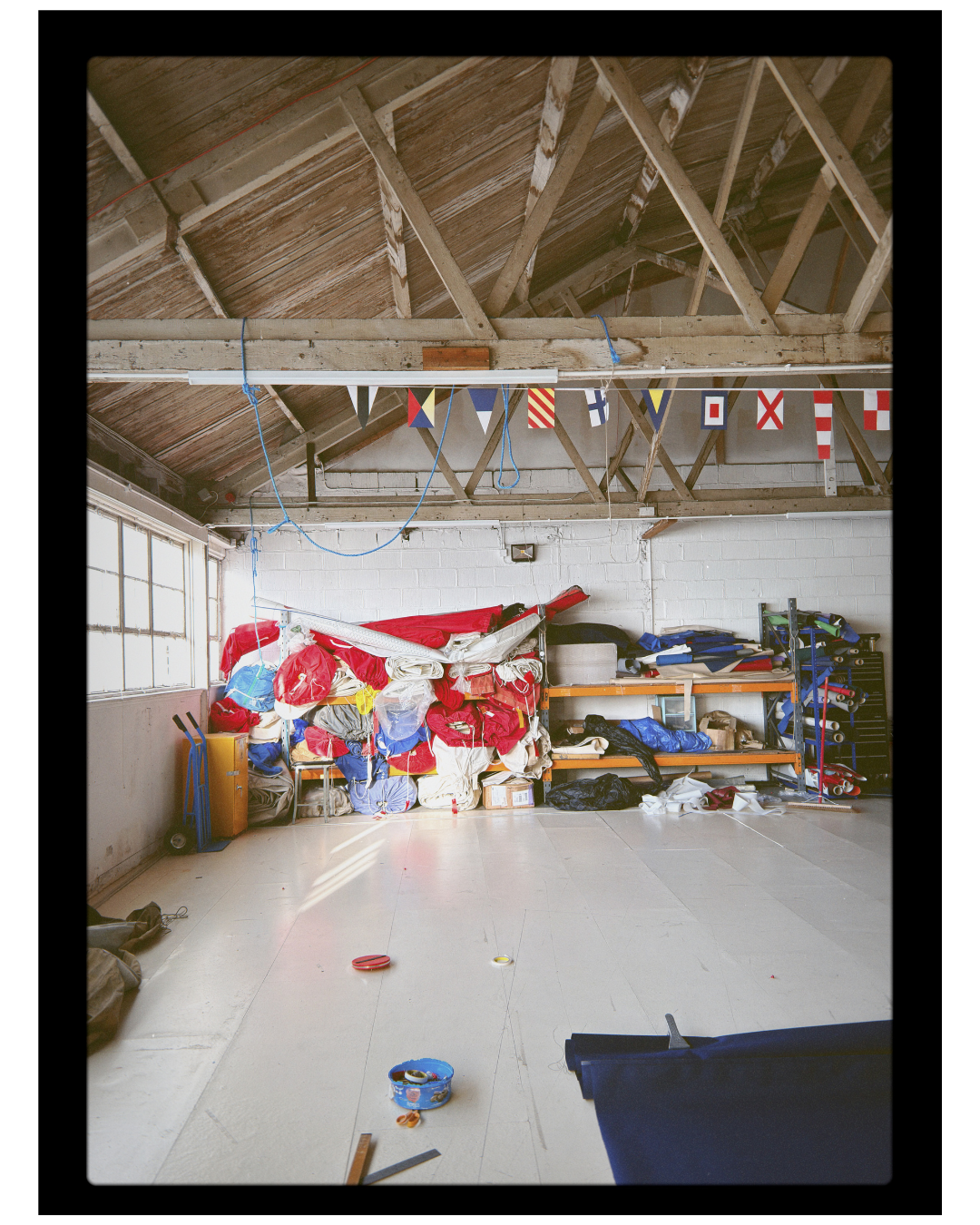 Garage with various items including a large colorful banner and shelves.